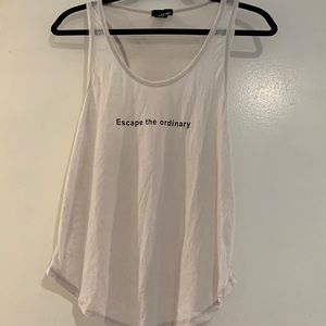 Wet Seal cream colored tank top with escape the ordinary written on the front